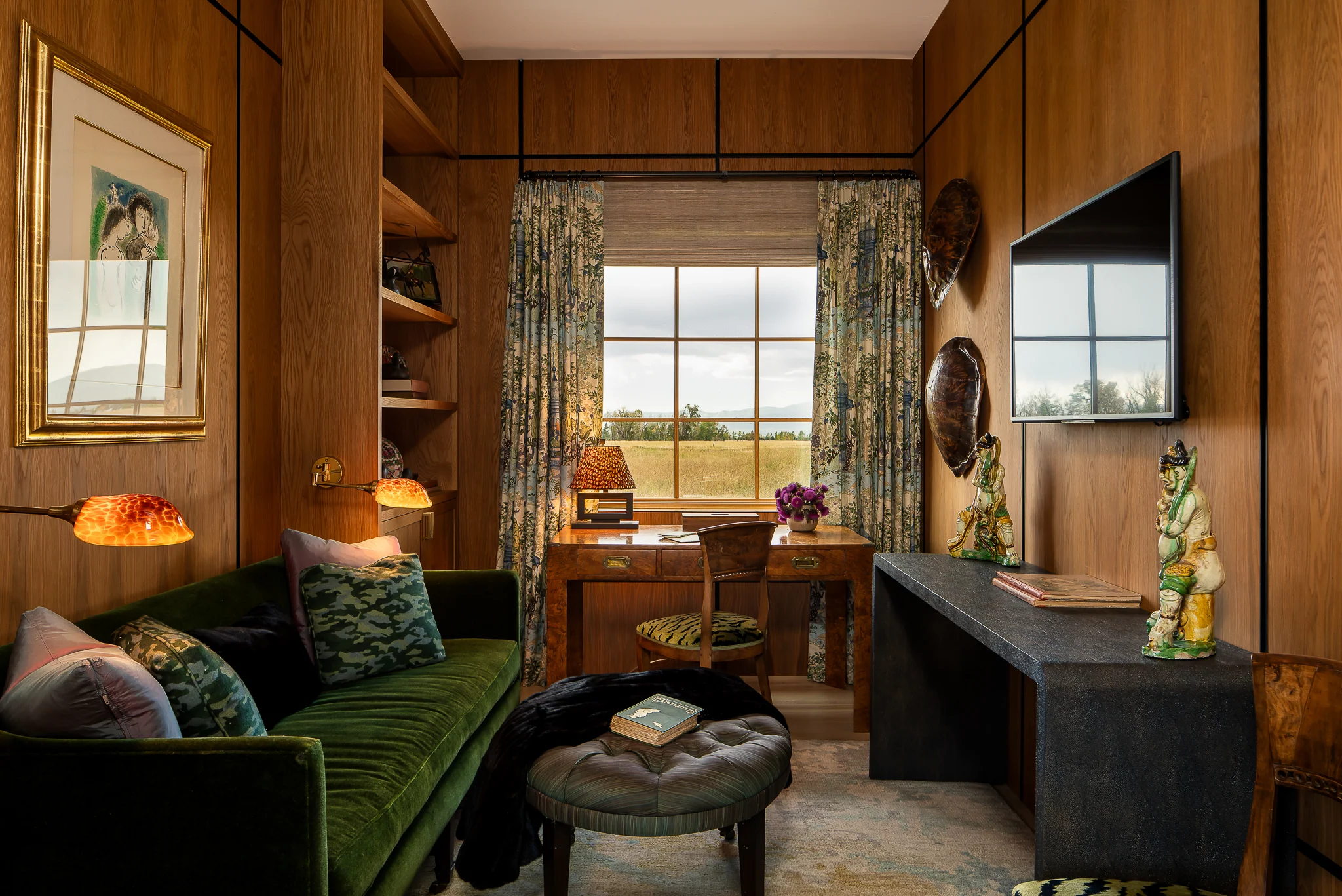 Wood-paneled study with a velvet sofa and floral curtains framing a meadow view — interior design photography Driggs Idaho, River's Edge